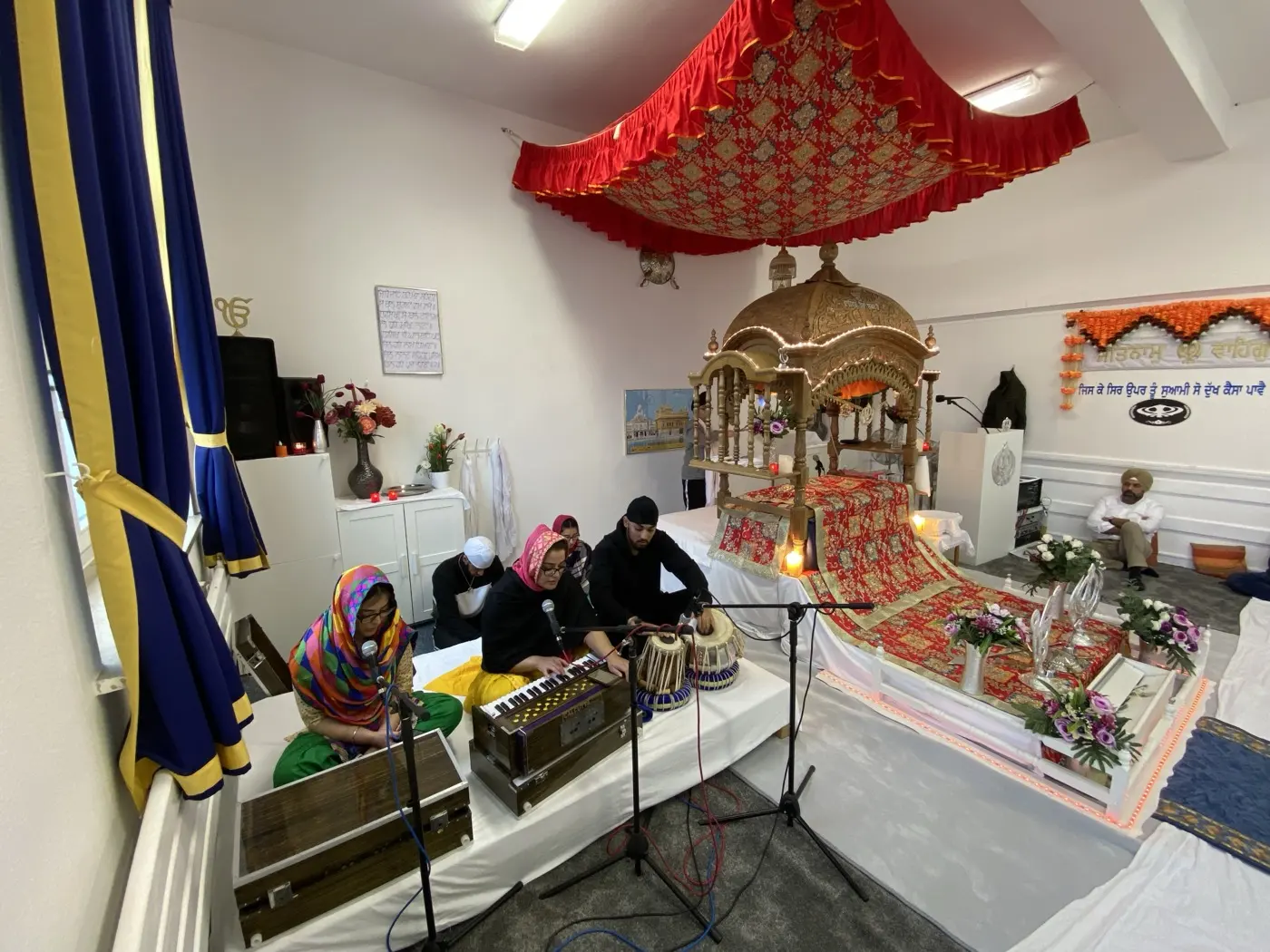 Kirtan im Darbar Sahib: Musikerinnen und Musiker mit Harmonium und Tabla neben dem Palki Sahib
