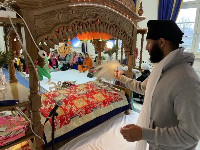 Ein Sevadar am Palki Sahib während des Gottesdienstes